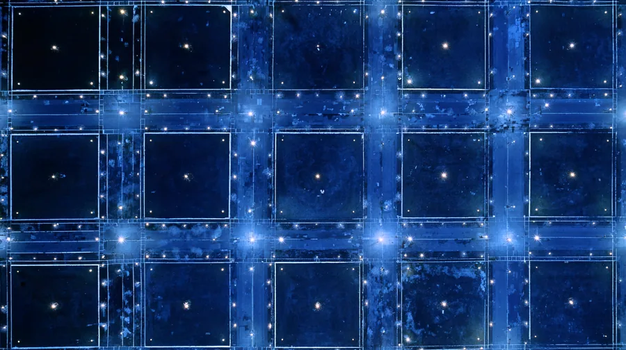 A data hall of black glass server monoliths receding to a single slit of white light